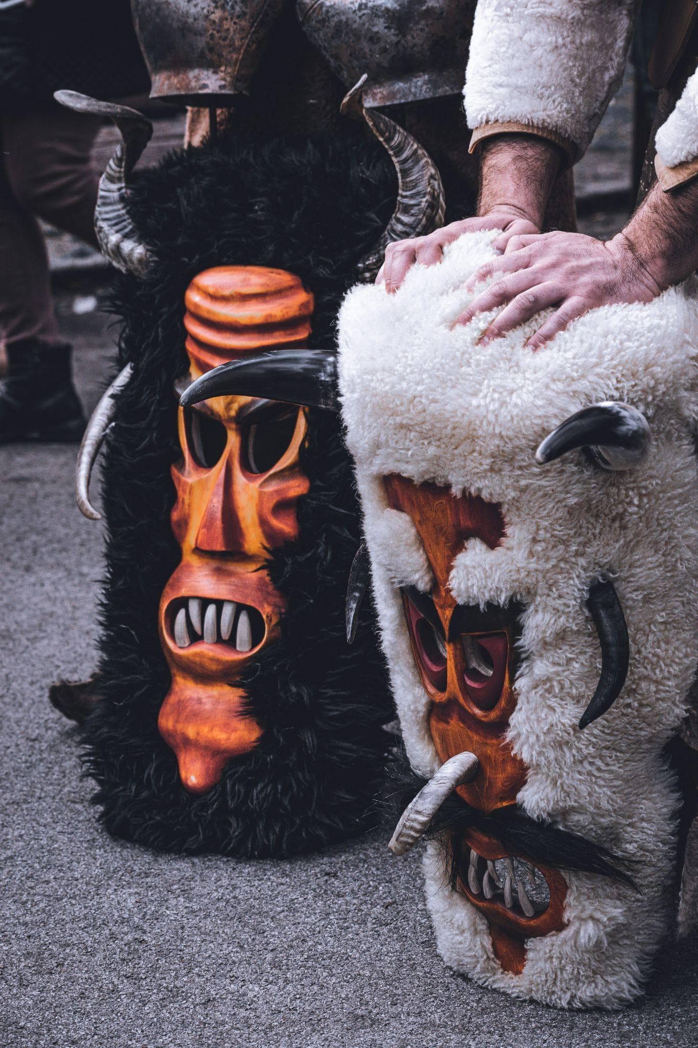 Two shaggy folk masks with carved wooden faces
