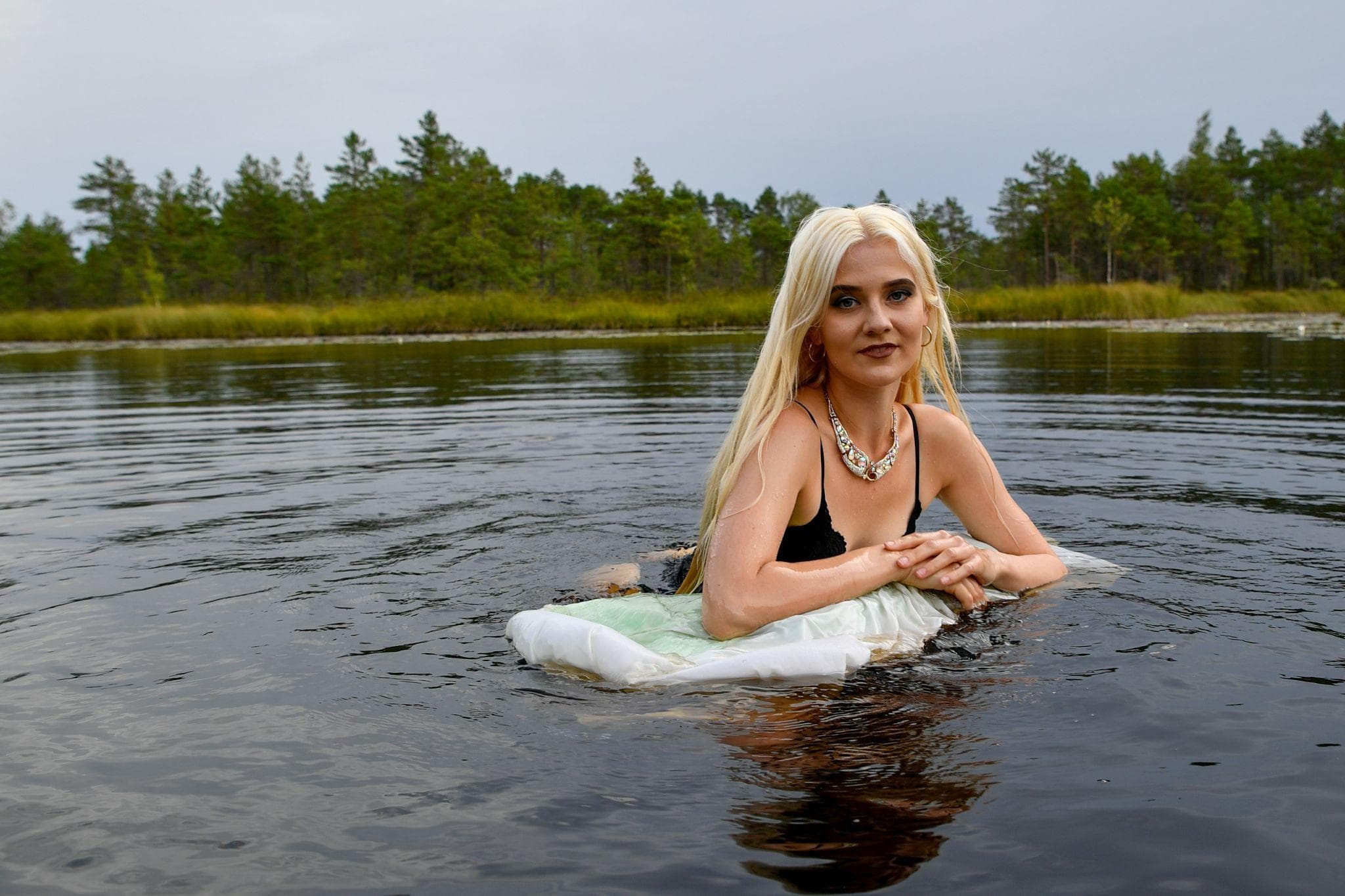 Person in water resting on a floating pillow